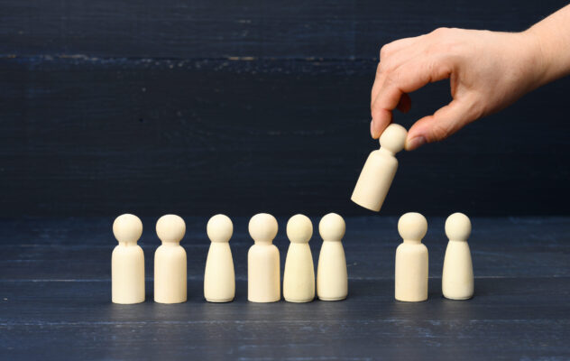 female hand holds a wooden figurine chosen from th 2022 06 22 14 49 01 utc scaled 1